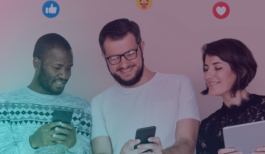 Tres personas están de pie juntas, sonriendo y mirando sus teléfonos móviles, con los iconos de reacción de las redes sociales —el pulgar hacia arriba, la carita que se ríe y el corazón— sobre sus cabezas.
