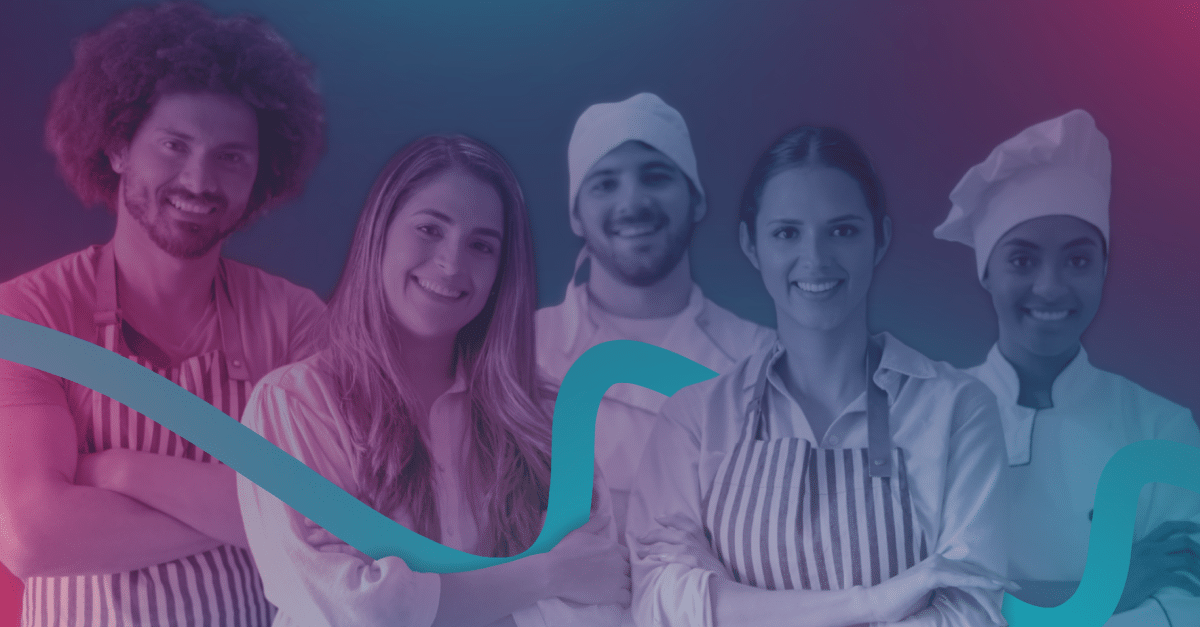 Cinq personnes vêtues d'uniformes de chef et de serveur posent ensemble en souriant, sur un fond présentant un dégradé de bleu et de rose, avec une ligne bleue ondulée au premier plan.