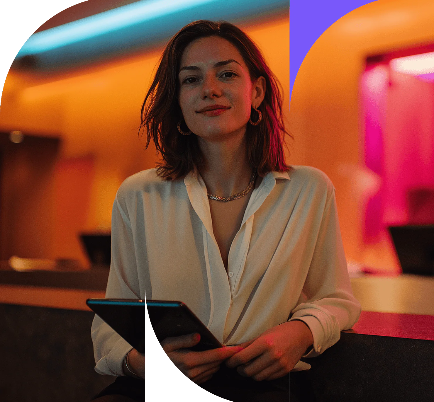 A woman with shoulder-length brown hair, wearing a white blouse and holding a tablet, sits in a stylish, warmly lit modern interior with orange and pink lighting accents—perfect for those seeking to improve hotel profitability.