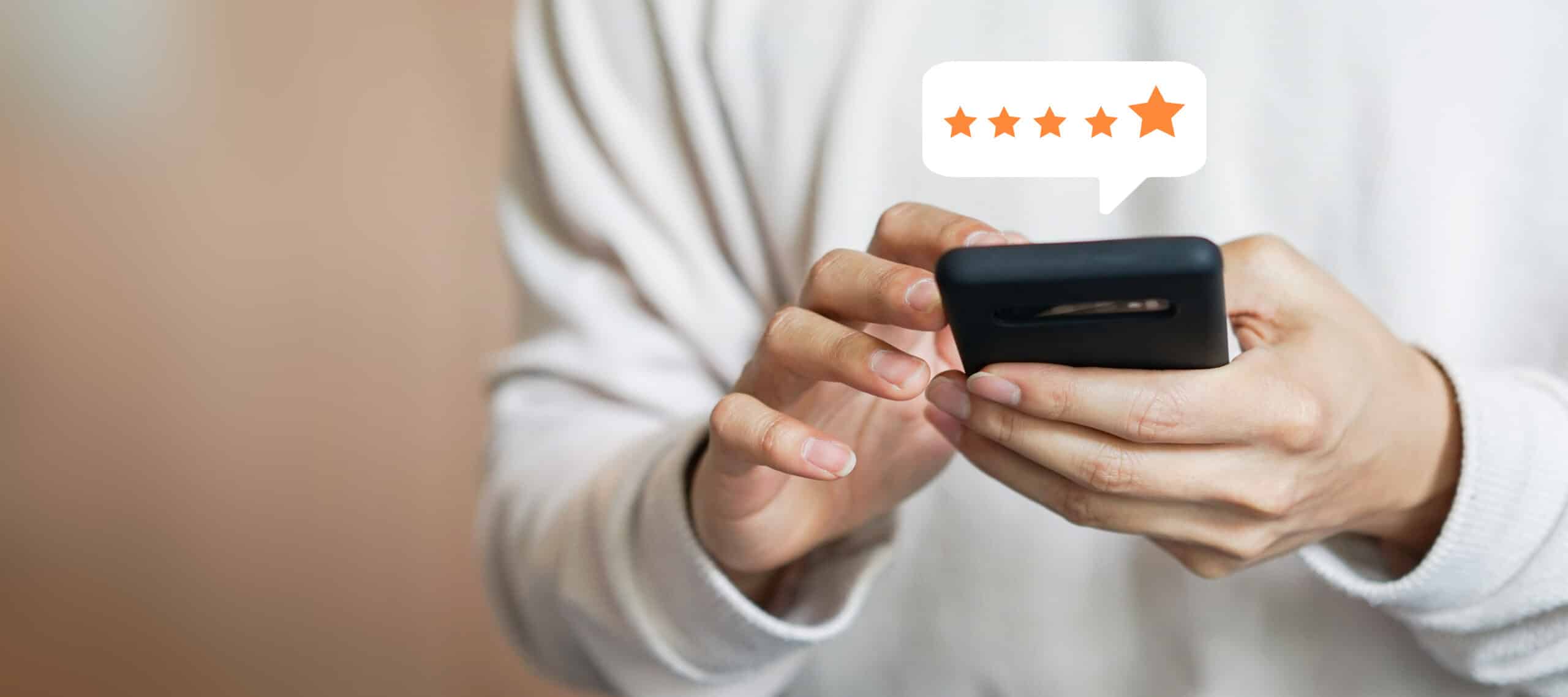 Une personne vêtue d'une chemise blanche utilise un smartphone, au-dessus duquel apparaît une bulle numérique indiquant une note de cinq étoiles.