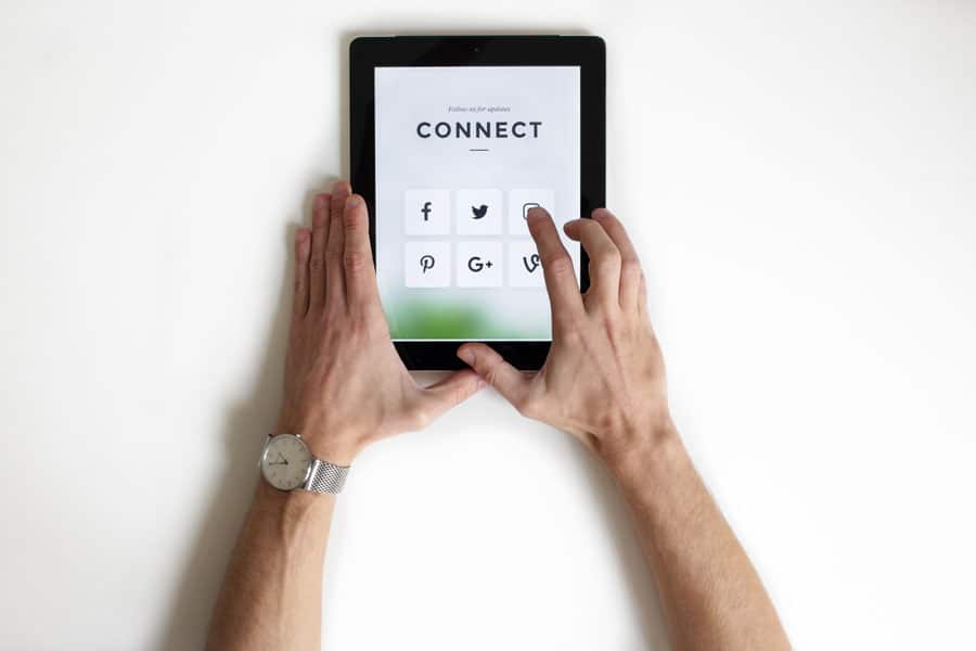 Una persona utiliza una tableta en la que aparecen iconos de redes sociales, entre ellos Facebook, Twitter, LinkedIn, Pinterest, Google Plus y Vine, con la palabra «CONNECT» en la parte superior.