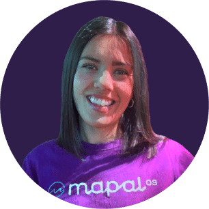Una mujer con el pelo liso y oscuro sonríe; lleva una camiseta morada de mapal.os. El fondo es un círculo liso de color morado oscuro.