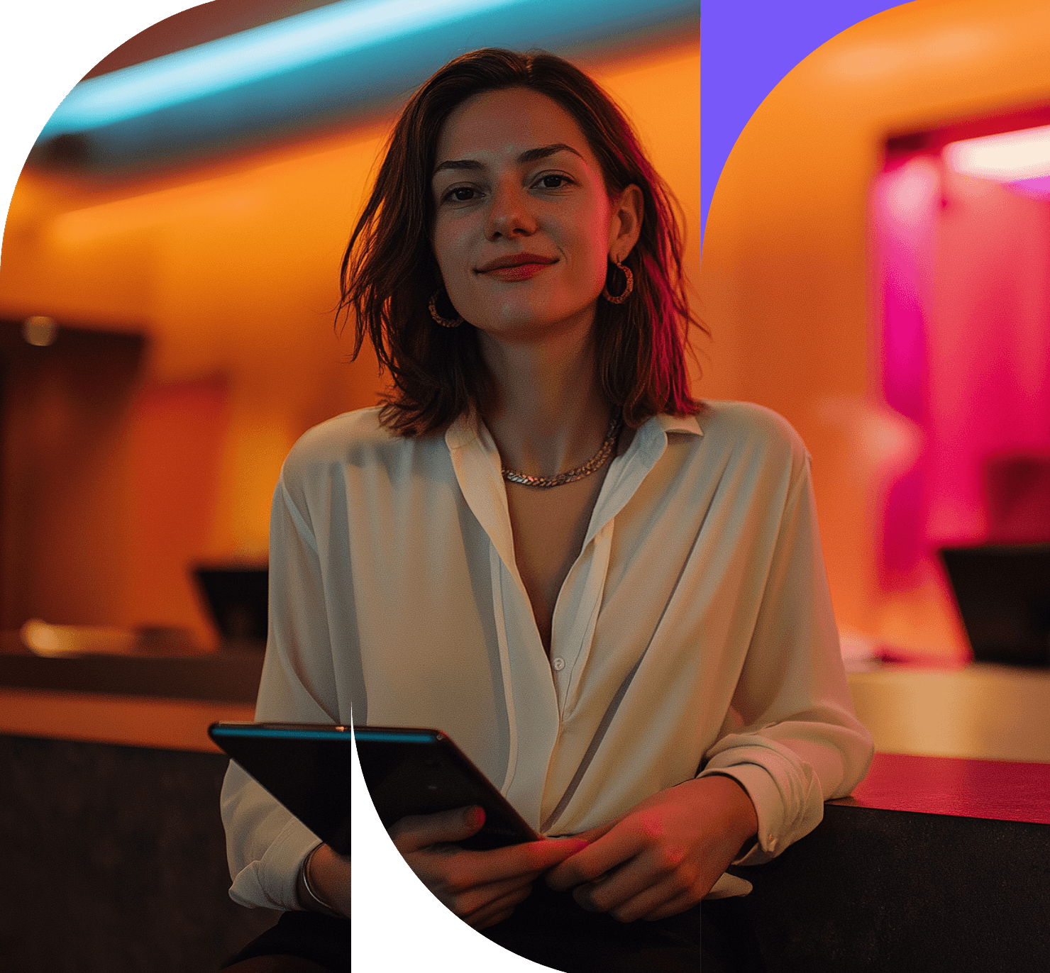 A woman with shoulder-length brown hair, wearing a white blouse and holding a tablet, sits in a stylish, warmly lit modern interior with orange and pink lighting accents—perfect for those seeking to improve hotel profitability.