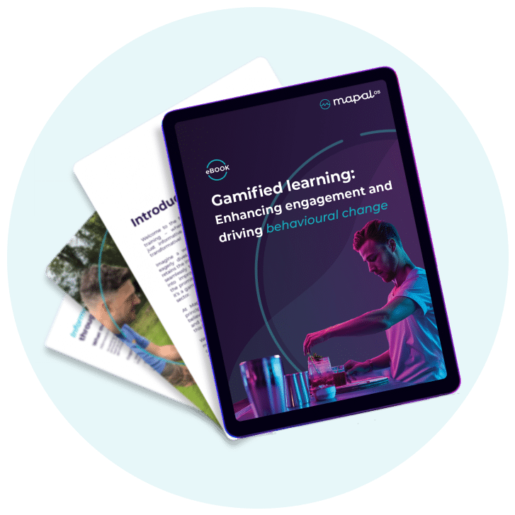 A tablet displays an eBook titled Gamified learning: Enhancing engagement and driving behavioural change, with two partially visible printed pages behind it.