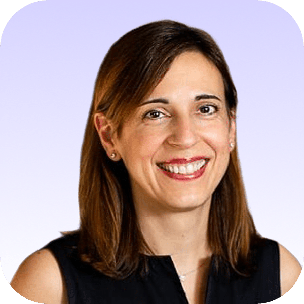 A woman with straight brown hair, wearing a sleeveless black top, smiles at the camera. The background is a light gradient from lavender to white, and the photo has rounded corners.