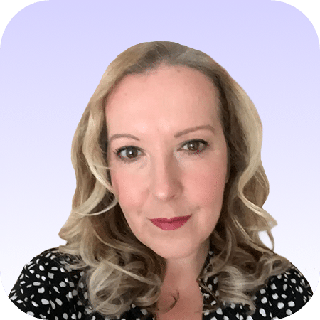 A woman with wavy blonde hair and red lipstick, wearing a black and white spotted top, poses in front of a light purple gradient background.